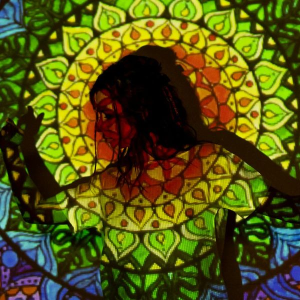 Silhouette of a woman meditating with a vibrant lotus flower glowing.